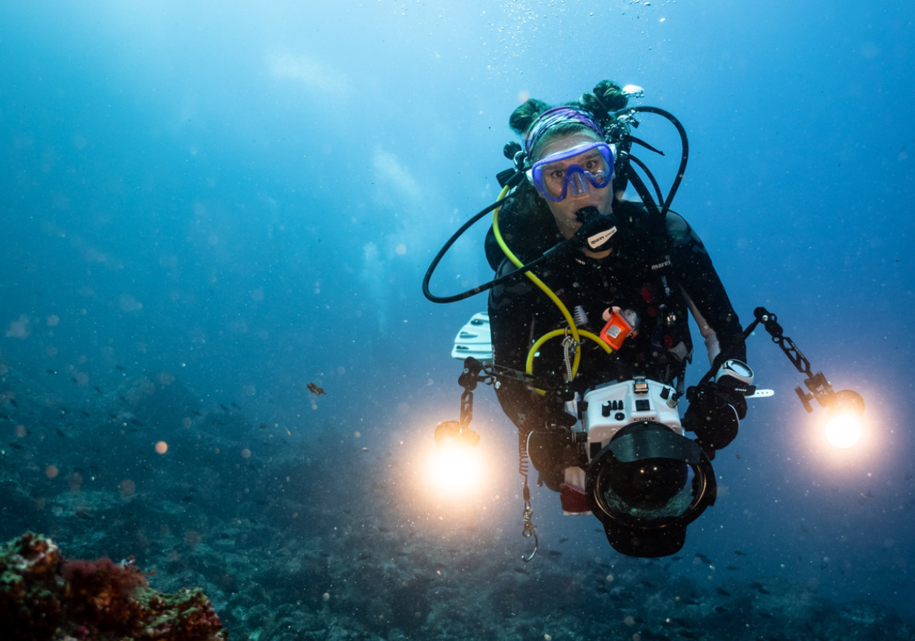 A scuba diver with a flashlight underwater