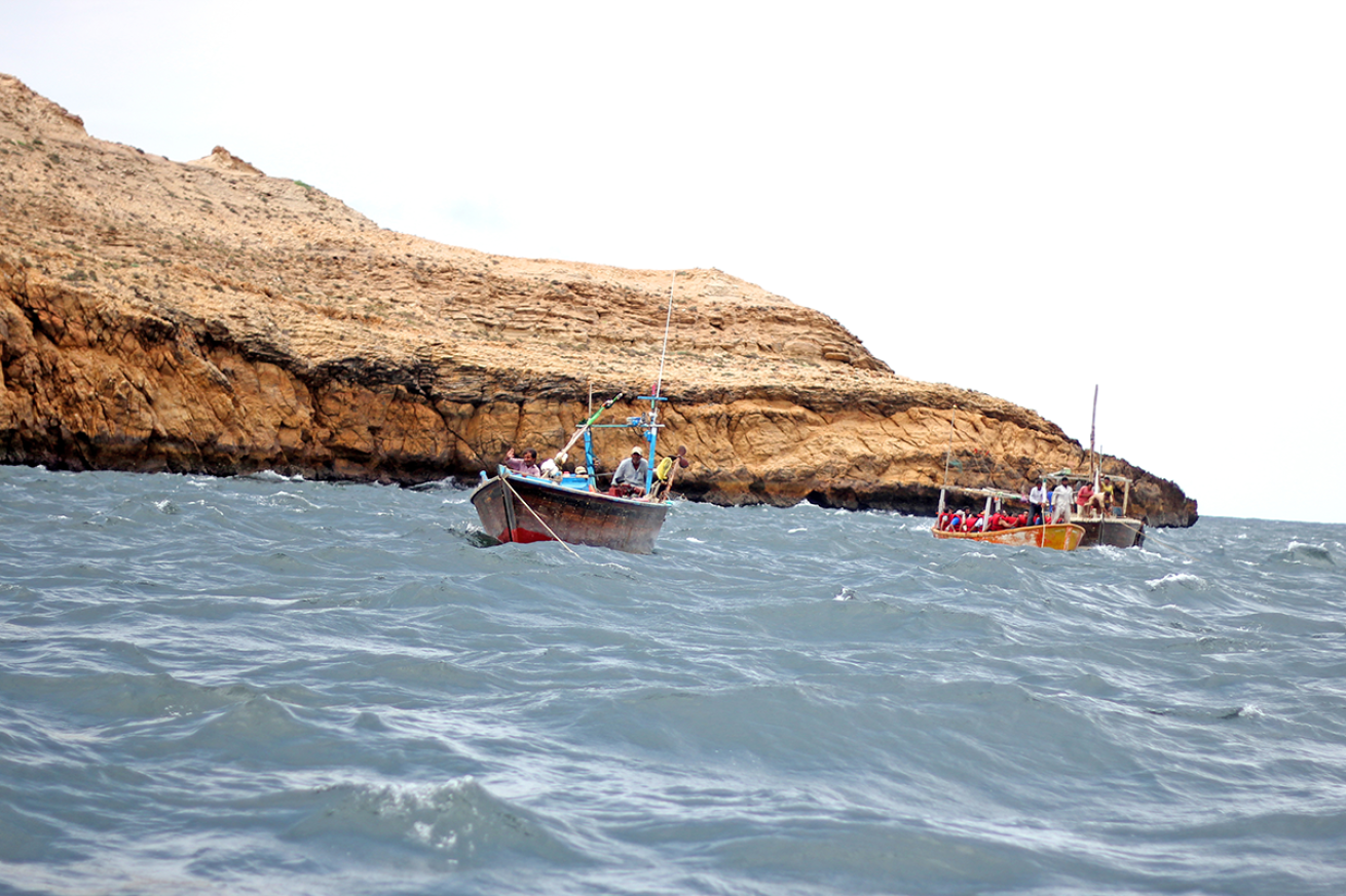 Two boats sailing off the coast.