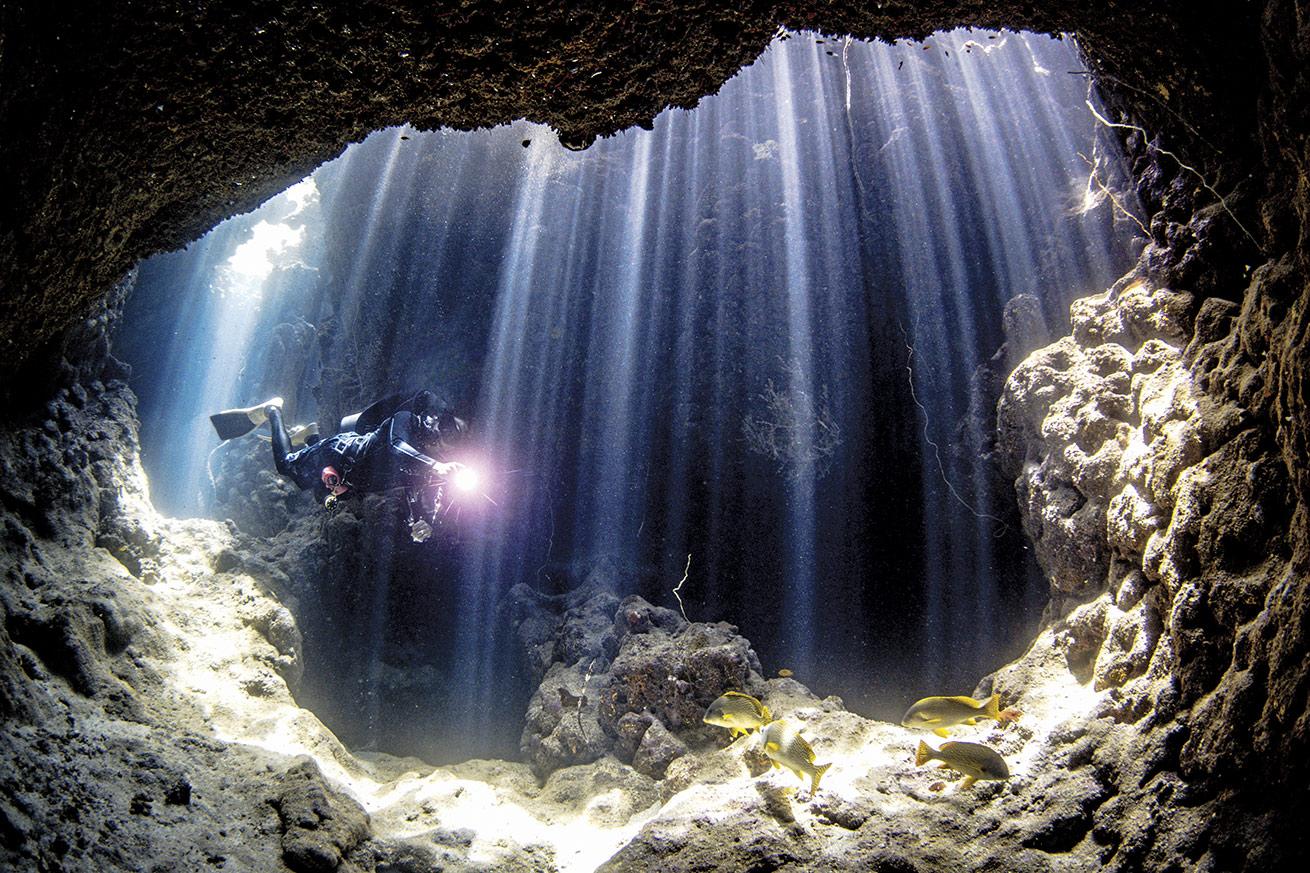 A diver fins toward the large exit of a cave complex at Suflani Reef just south of Yanbu.
