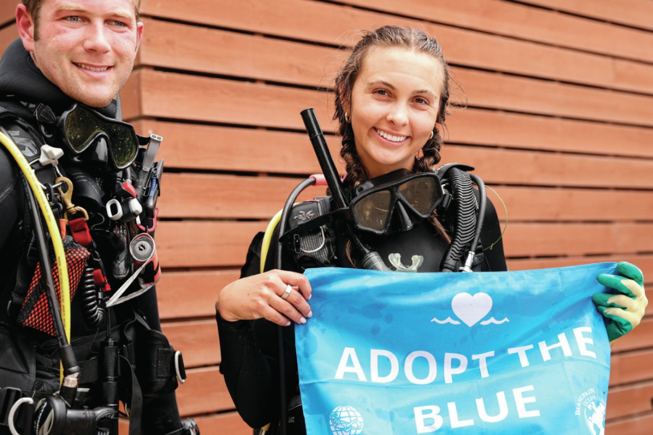 A person wearing scuba gear holding a flag