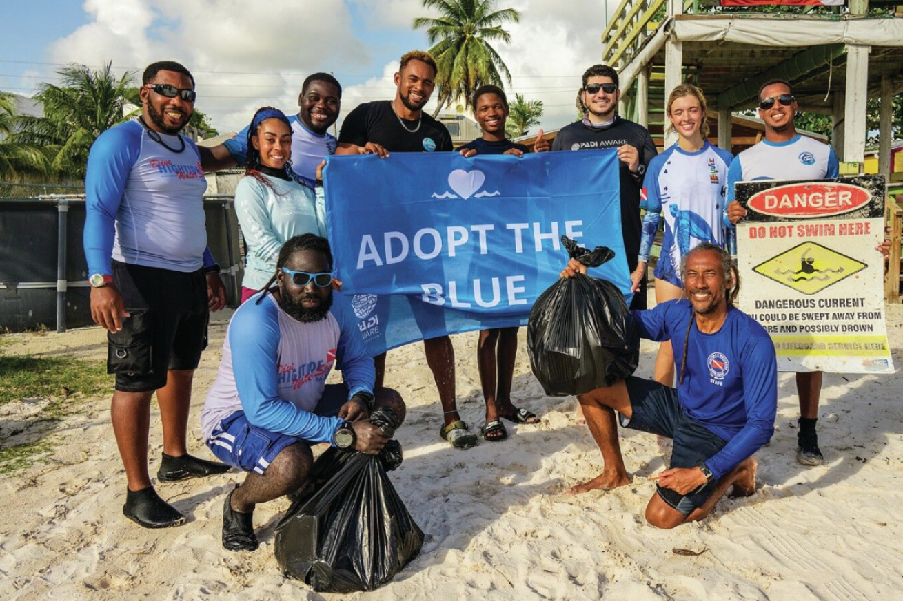 A group of people holding a sign and trash bags