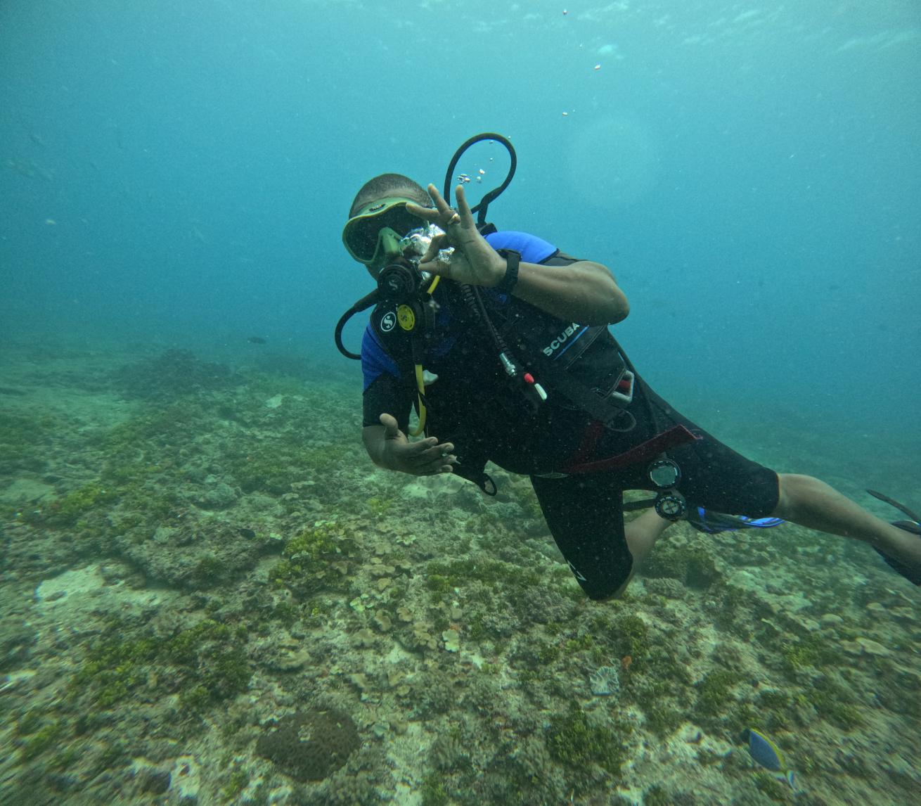 scuba diver giving okay sign underwater