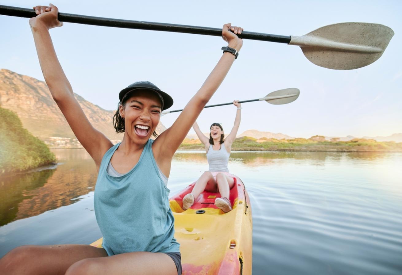 two women kayaking and smiling