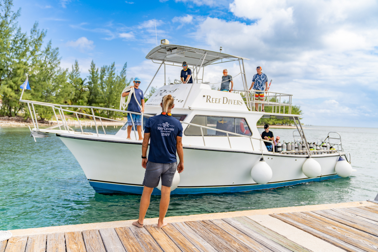 A group of people standing on a dock next to a boat