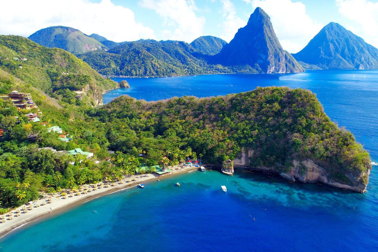 A beach with trees and mountains in the background with Anse Chastanet in the background