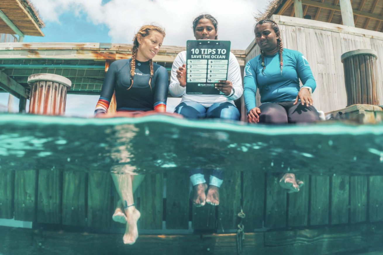 A group of women sitting on a dock holding a clipboard
