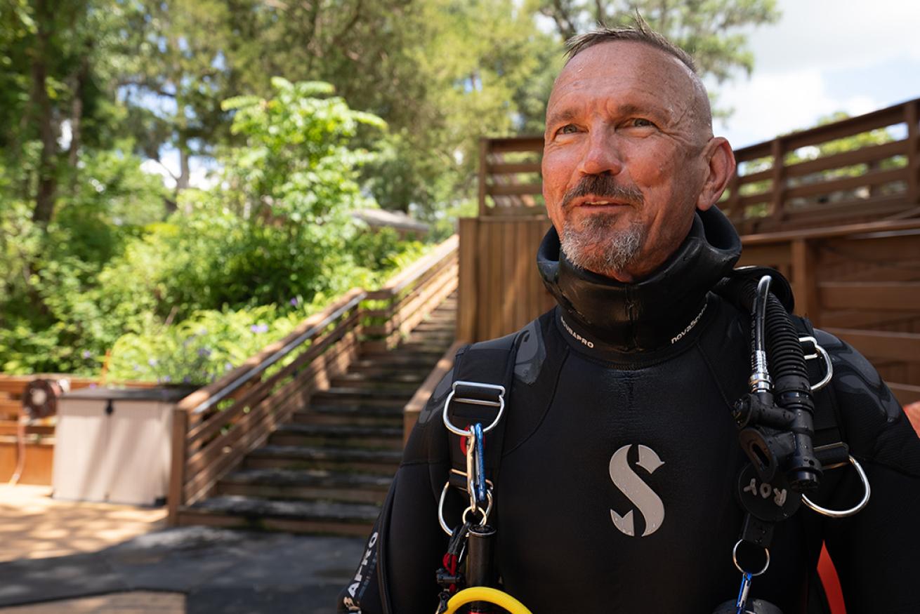 a diver wearing a semidry wetsuit getting ready to dive at blue grotto 