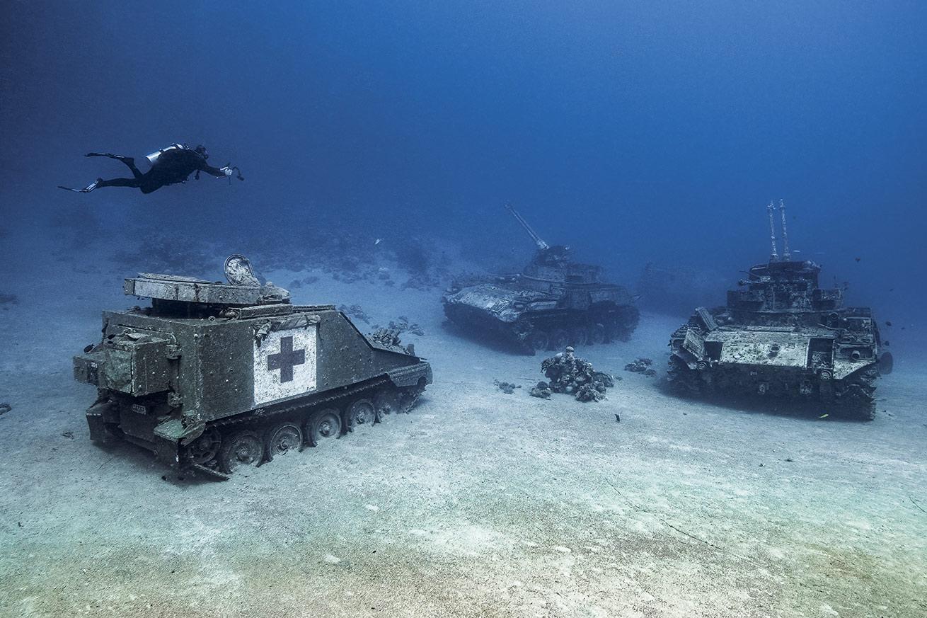 Sunken military vehicles dot the sandy seafloor at the Underwater Military Museum in Aqaba, Jordan.