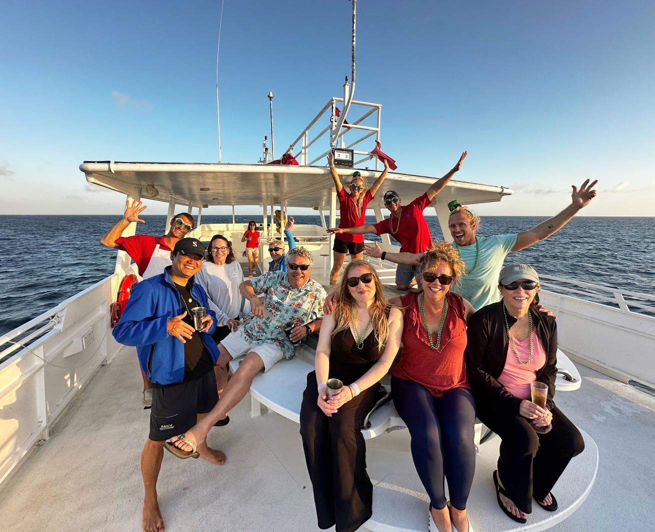 divers on top deck of boat smiling