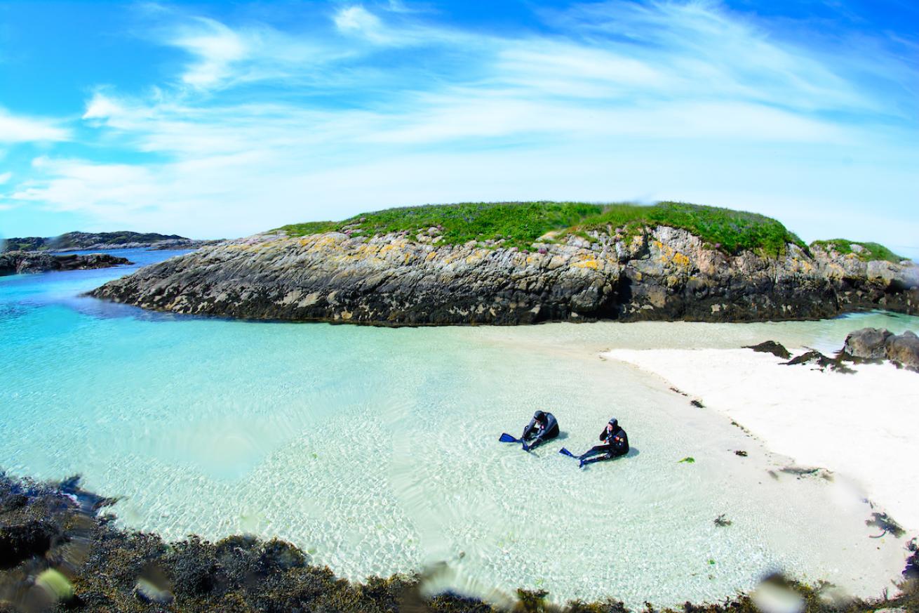 Snorkelers gear up for a dive at  Snorkel Beach in Hebrides Scotland