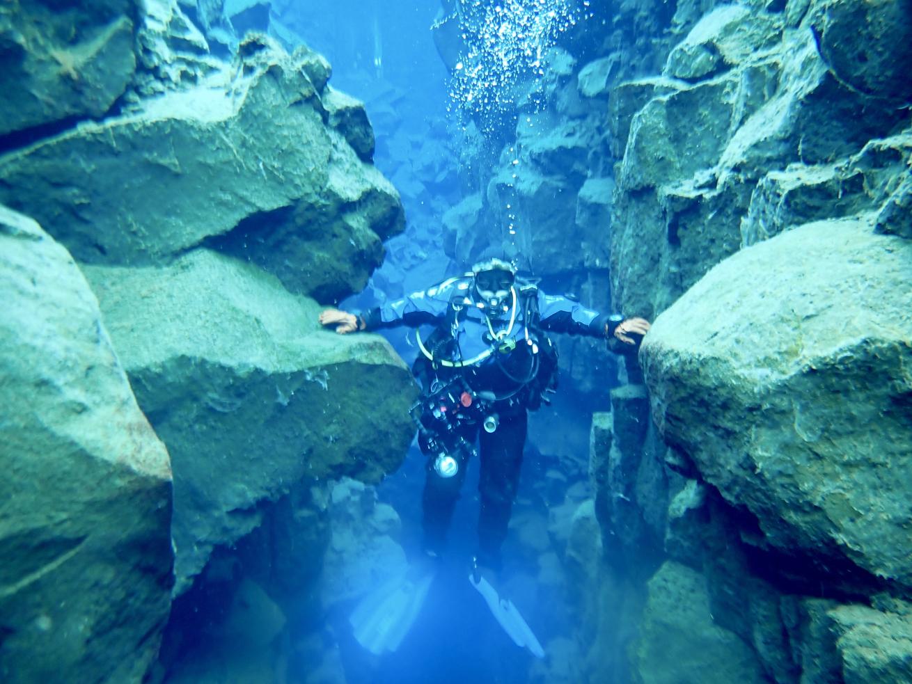 Legendary diver Sally Wahrmann loves wrecks and cold water diving. Here, she touches the continental plates at the Silfra Fissure in Iceland.